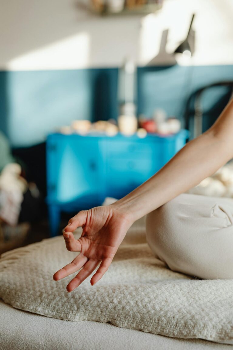 Close-up of a woman's hand in a meditation pose indoors, capturing serenity and relaxation.